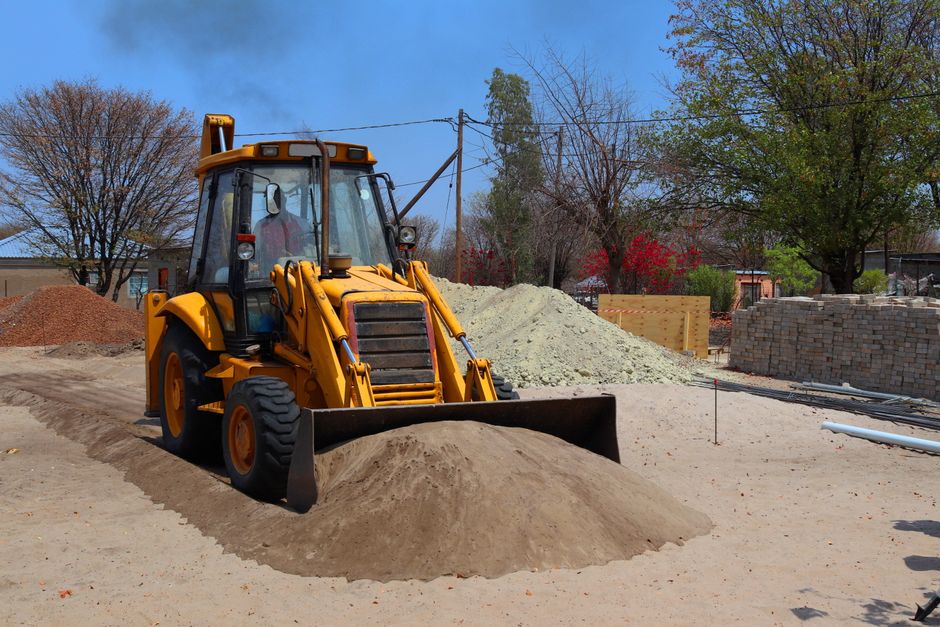 Excavator working on drain line replacement